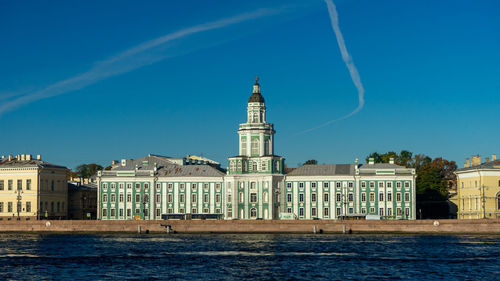 Buildings in city against blue sky