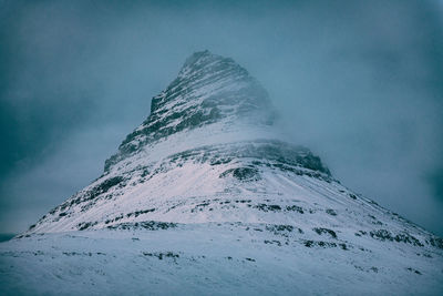 Low angle view of snowcapped mountain against sky