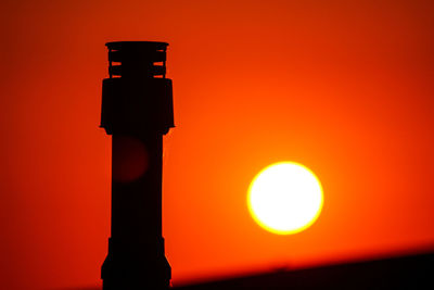 Close-up of illuminated lamp against orange sky