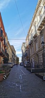 Street amidst buildings in city against sky