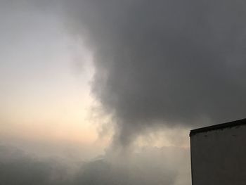 Low angle view of smoke emitting from chimney against sky