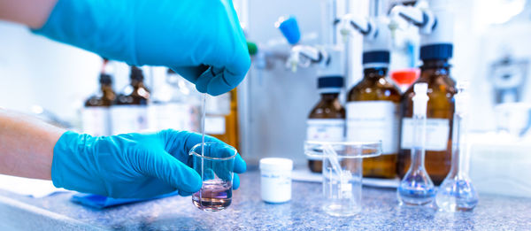 Cropped hand of scientist holding vial in laboratory