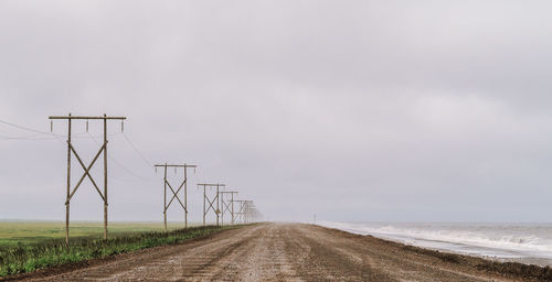 Road amidst field against sky