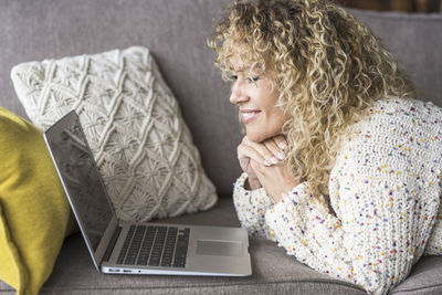 Midsection of woman using mobile phone while sitting on sofa