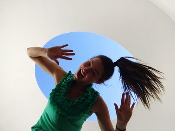 Low angle portrait of carefree woman dancing