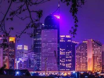 Illuminated buildings against sky at night