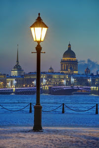 Illuminated street light in city at dusk