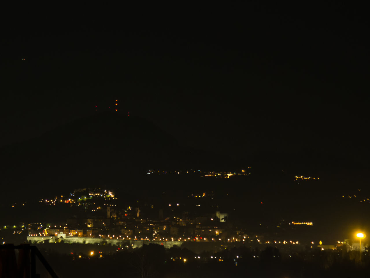 HIGH ANGLE VIEW OF ILLUMINATED BUILDINGS AGAINST SKY AT NIGHT