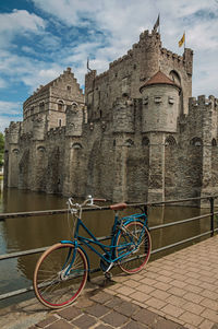 Bridge and bike in front of gravensteen castle in ghent. a city full of gothic buildings in belgium.