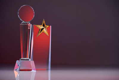 Close up of two glass trophies with red reflection