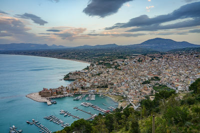 High angle view of townscape by sea against sky during sunset