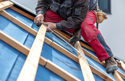 Low section of man standing on wooden wall