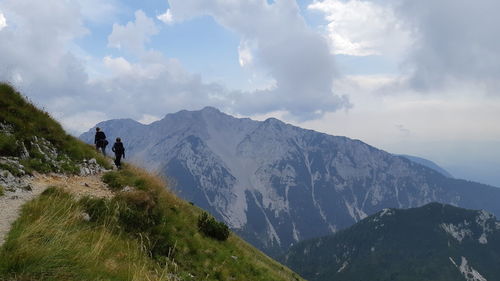 People walking on mountain against sky