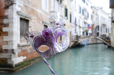 Handmade face mask in venice with background of famous canal, venice italy.