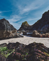 Scenic view of sea and mountains against sky at kynance cove in cornwall, england