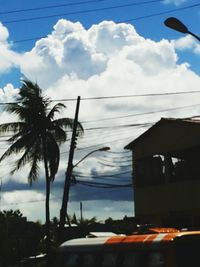 Low angle view of power lines against cloudy sky