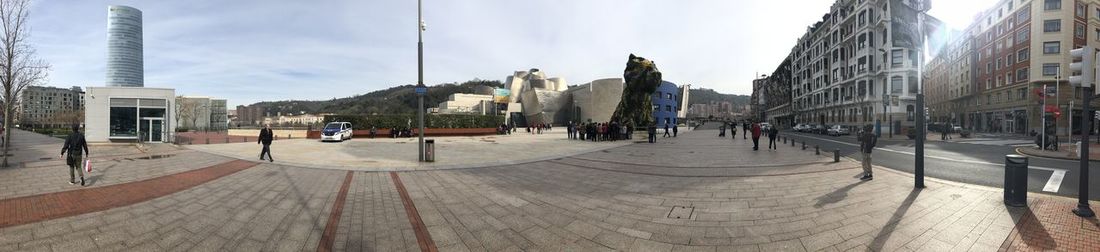 Panoramic view of city street and buildings against sky