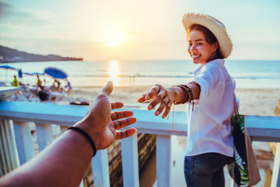 People enjoying at beach against sky