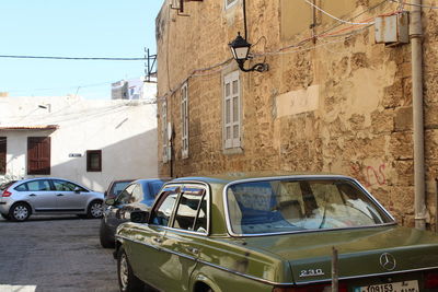 Vintage car on street against buildings in city