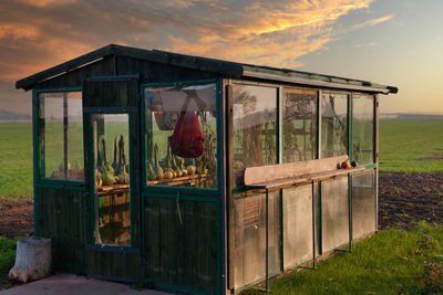 Built structure on field against sky during sunset