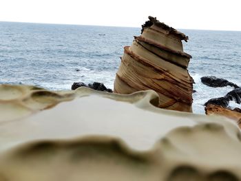 Scenic view of rocks on beach against sky