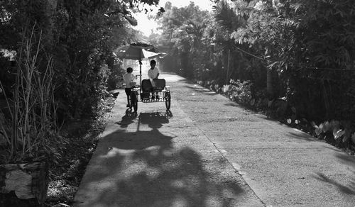 Rear view of people walking on footpath