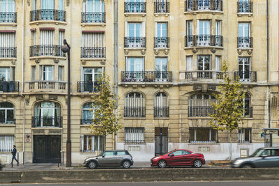 Cars on road by building in city