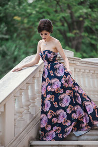 Portrait of woman standing by railing