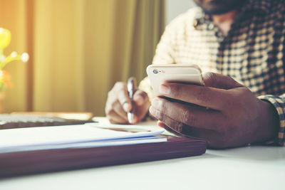 Midsection of man using mobile phone