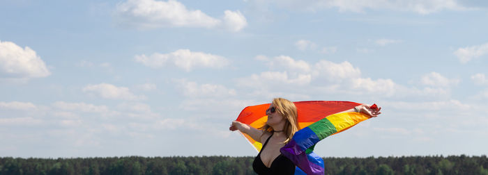 Side view of woman with umbrella standing on field