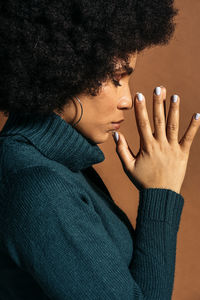 Close-up portrait of woman with tattoo on hand