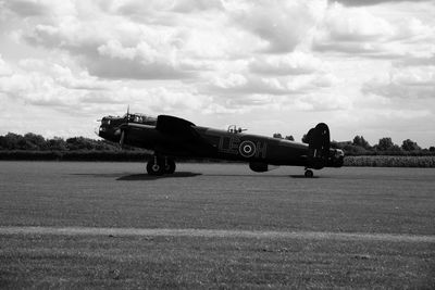 Airplane on field against sky