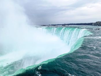 Scenic view of waterfall against sky