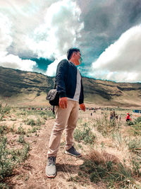 Full length of man standing on field against sky