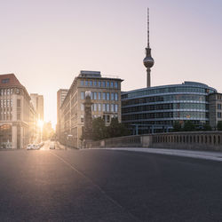 Fernsehturm and buildings against clear sky during sunset