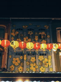 Low angle view of illuminated lanterns hanging at night