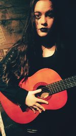 Close-up of young woman playing guitar