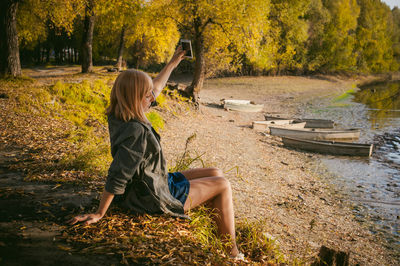 Side view of a girl sitting in a forest