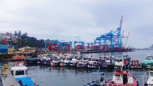 Boats moored at harbor against sky