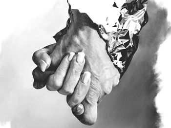 Close-up of man holding hands against sky