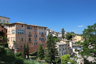 Buildings in town against clear blue sky