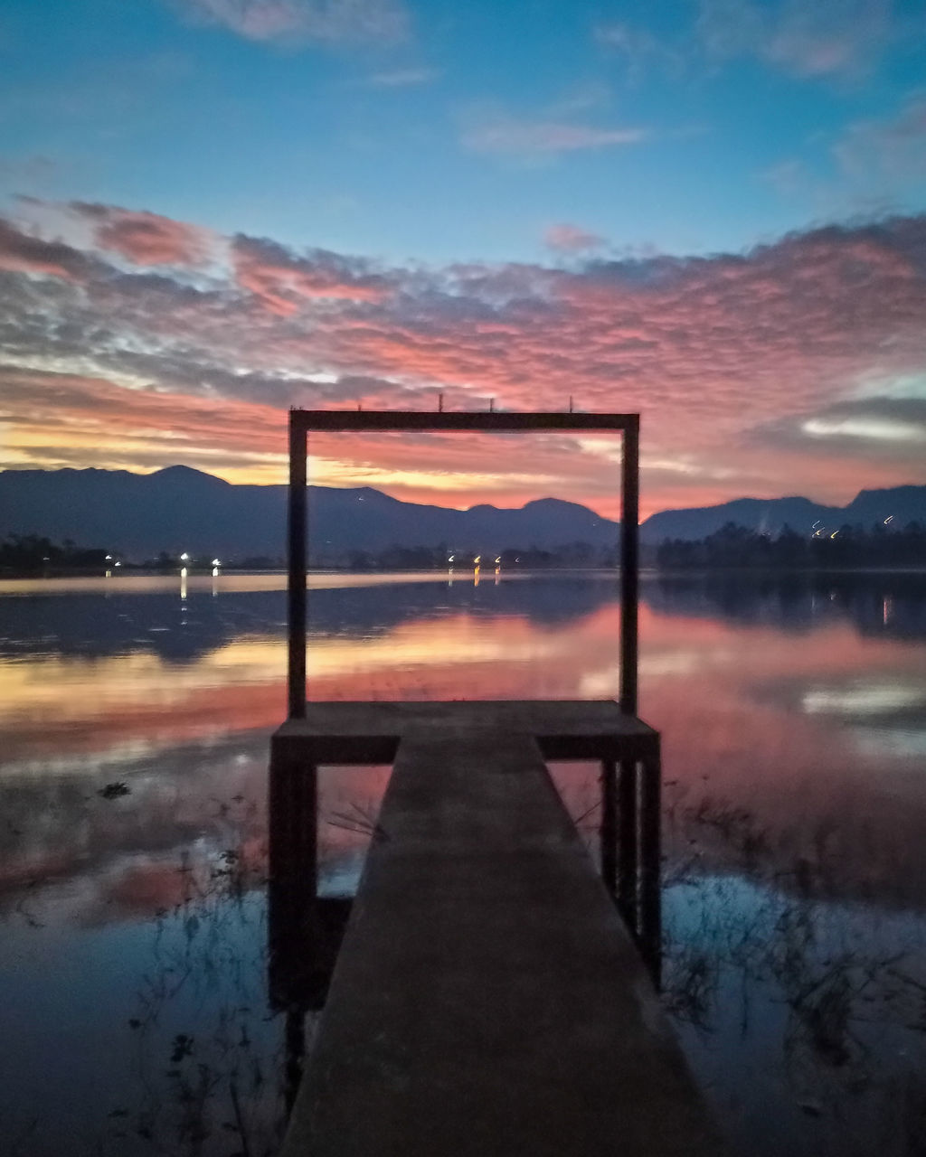 SCENIC VIEW OF LAKE AGAINST ORANGE SKY