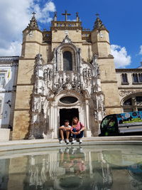 People in front of building against sky