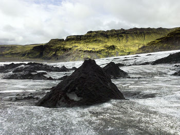 Scenic view of rock on landscape against sky