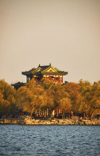 View of building by lake against sky