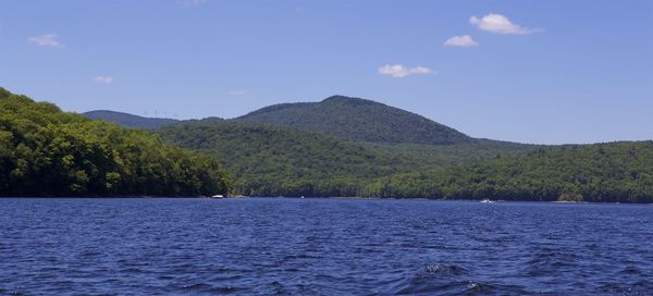 Scenic view of lake and mountains against blue sky