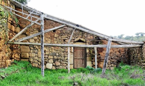 Abandoned building on field against clear sky