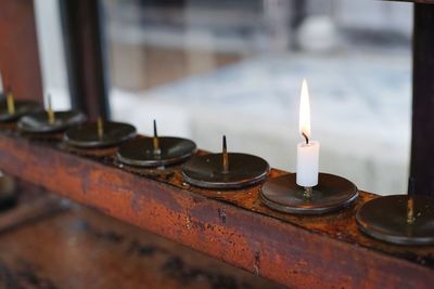 Close-up of illuminated candles on table