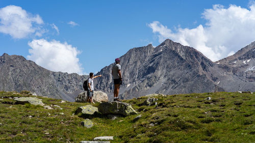 Panoramic view of people on rock against sky