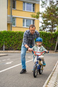 Portrait of boy riding push scooter on road